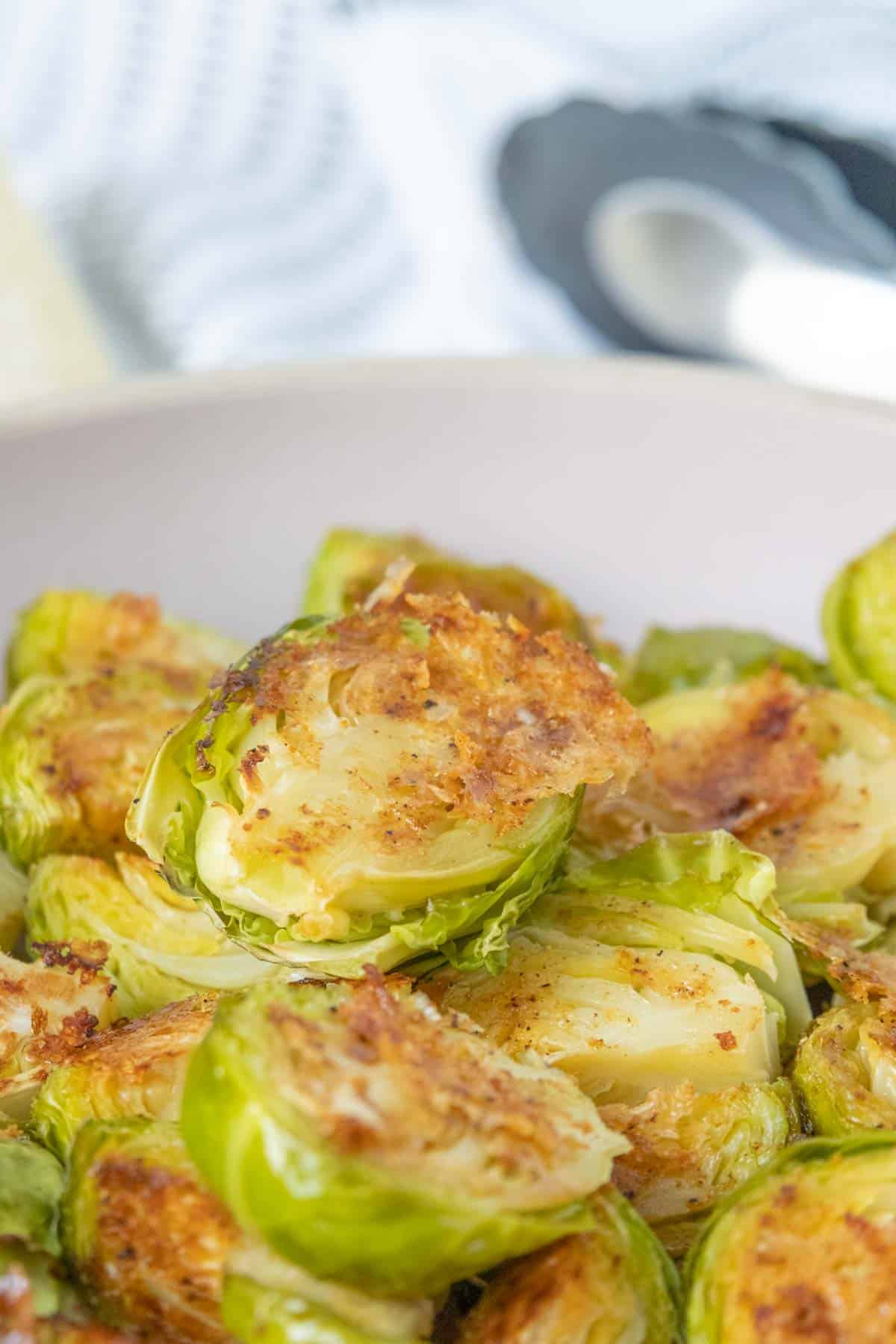 Roasted brussels sprouts in a white bowl.