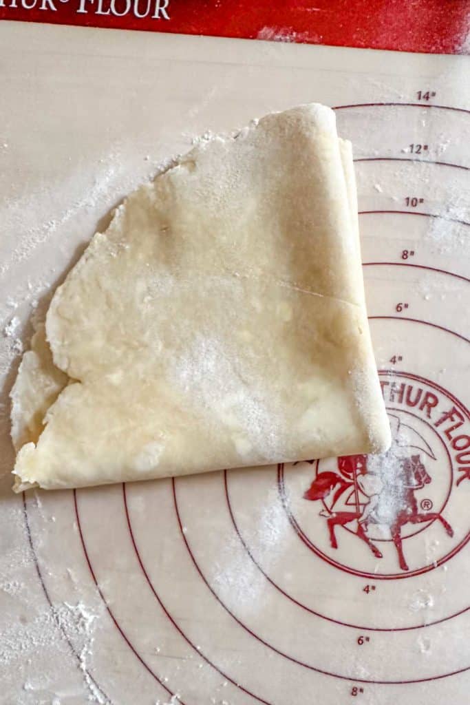 A piece of pastry dough on a cutting board.