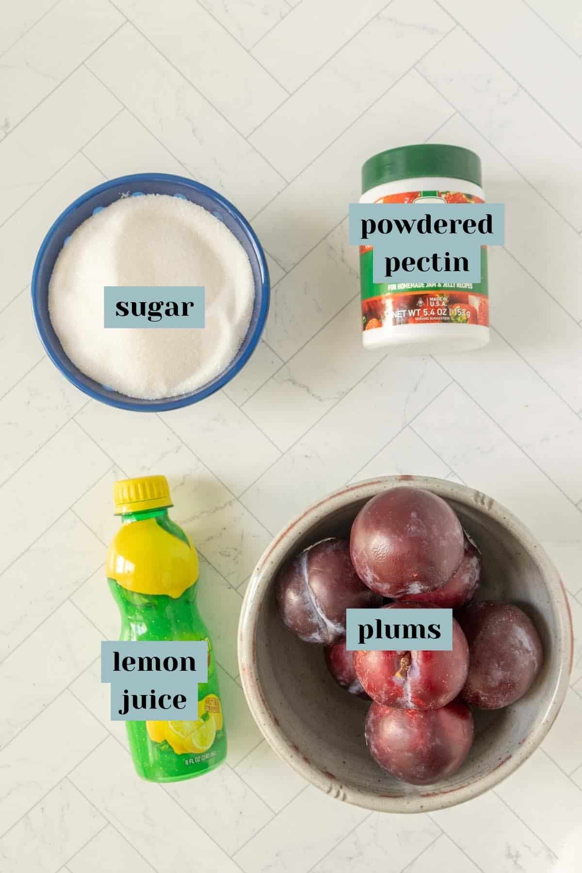 The ingredients for a plum dessert are shown on a marble countertop.