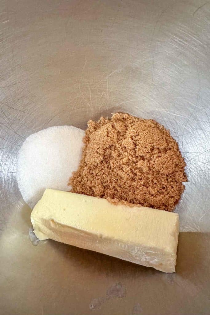 Butter, sugar and brown sugar in a metal bowl.