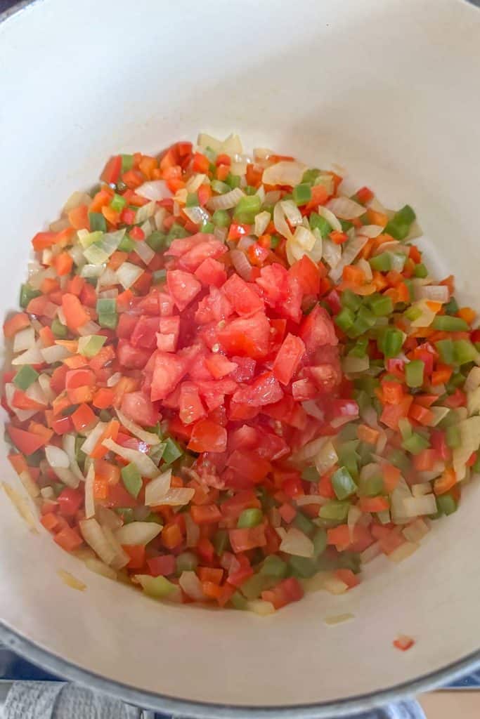A bowl of chopped vegetables in a pan on top of a stove.