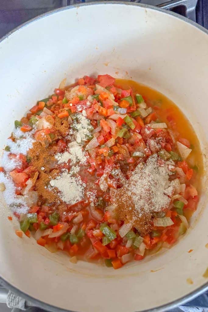 A large pot filled with vegetables and seasonings.