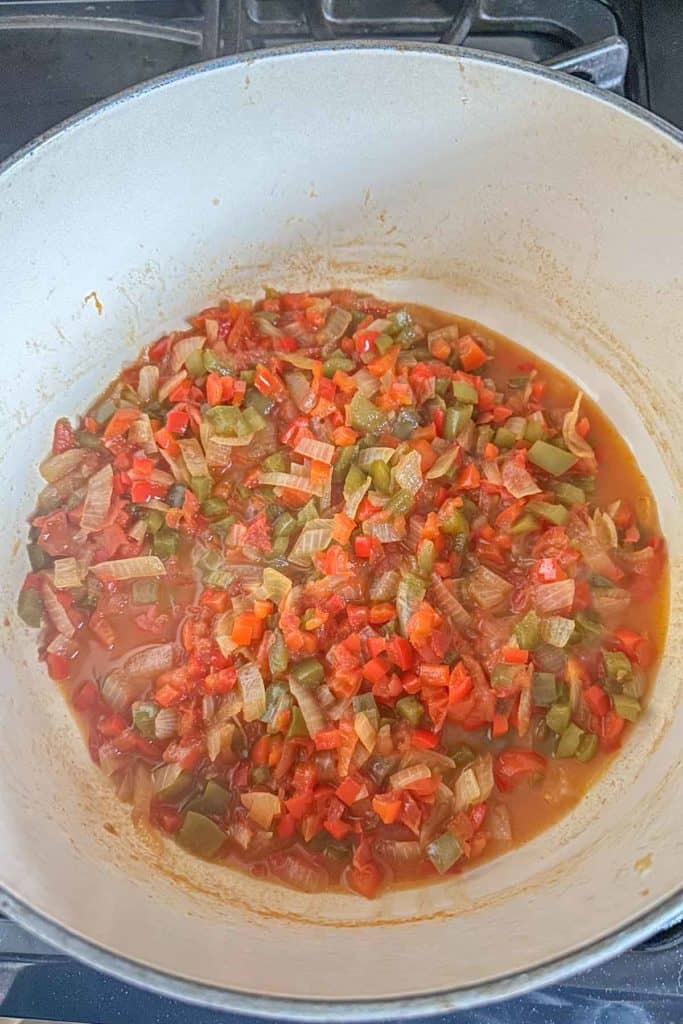 A wok filled with vegetables on a stove top.