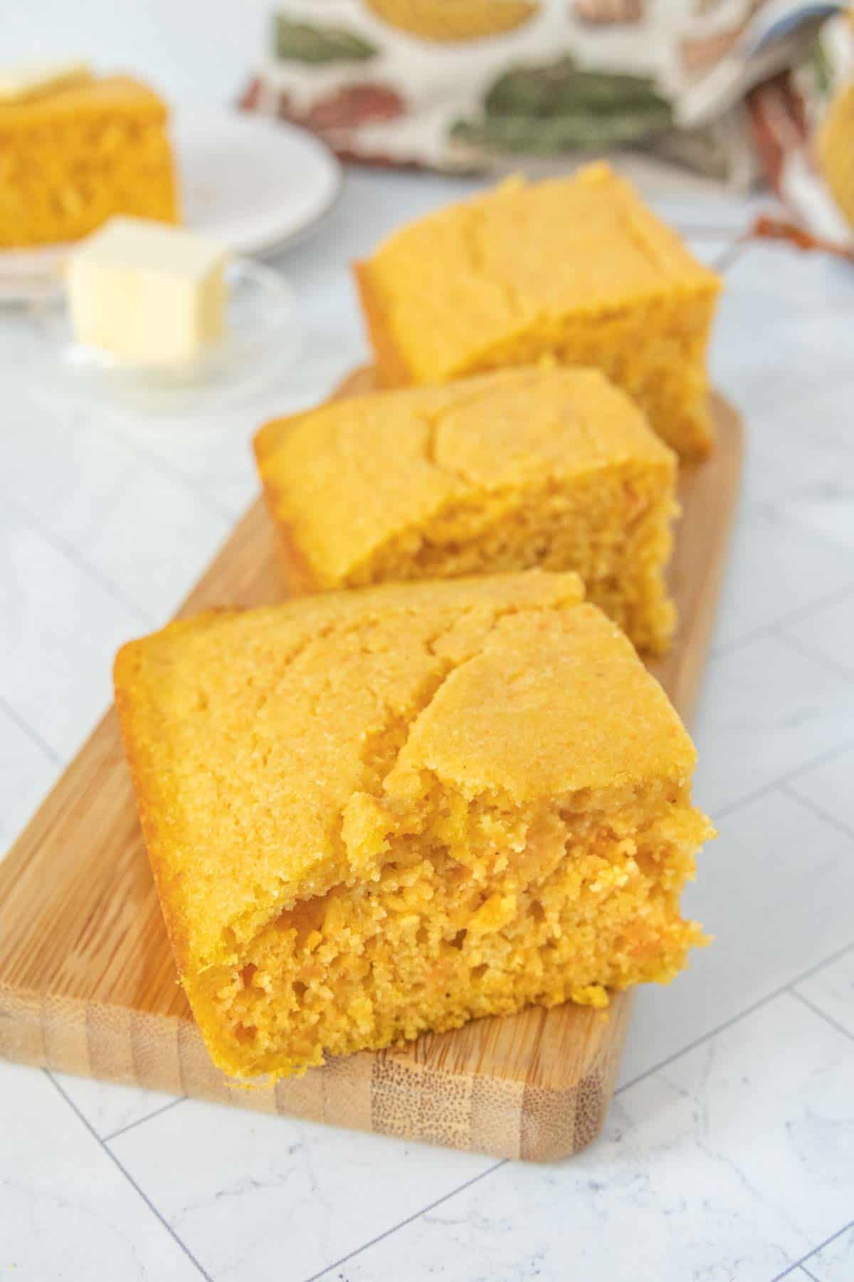 Cornbread on a cutting board with butter.