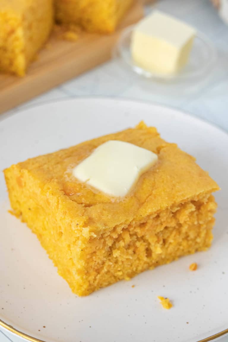 Cornbread on a plate with butter on it.