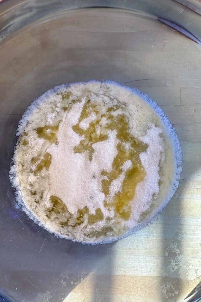 A bowl filled with melted butter and sugar on top of a wooden table.