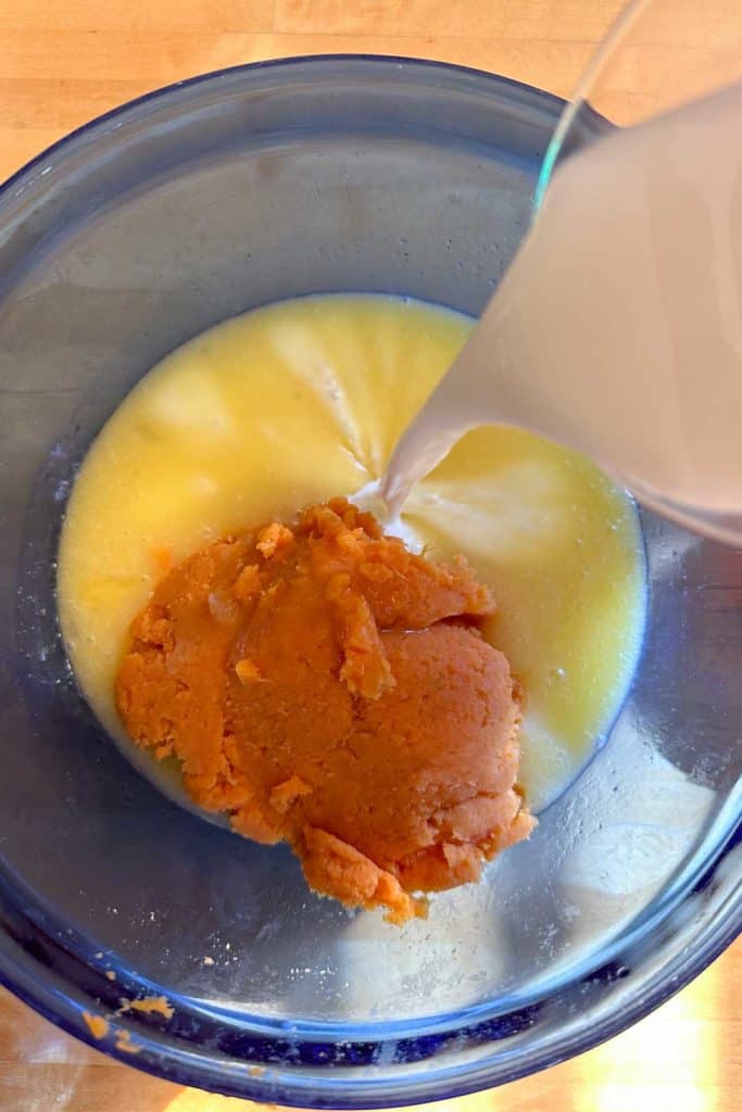 A glass of milk is being poured into a bowl.