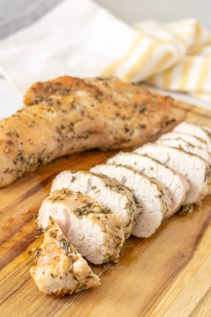 Sliced turkey breast on a wooden cutting board.