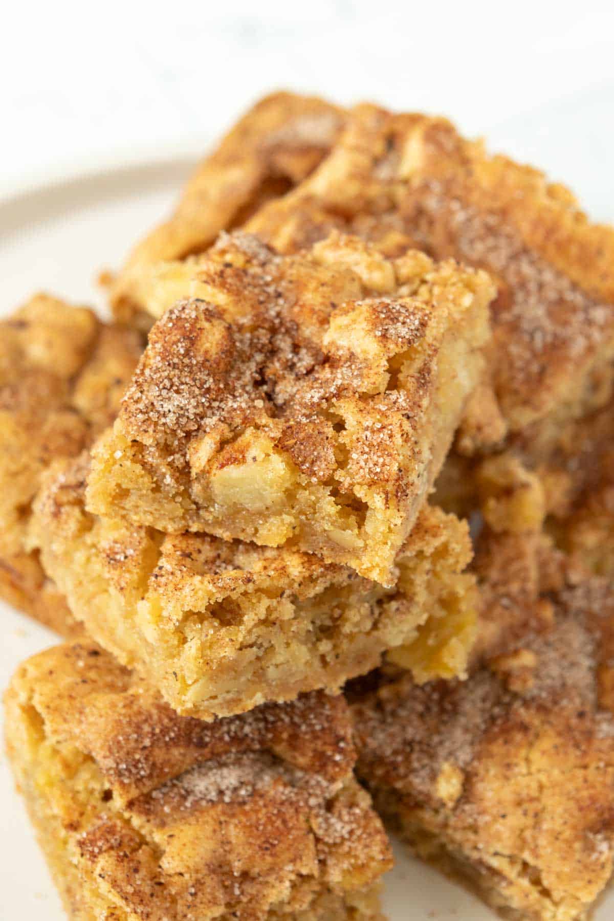 A stack of cinnamon apple squares on a white plate.