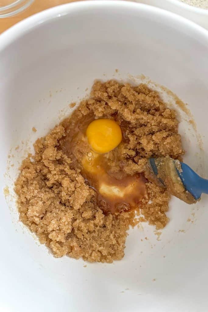 An egg in a white bowl with sugars.