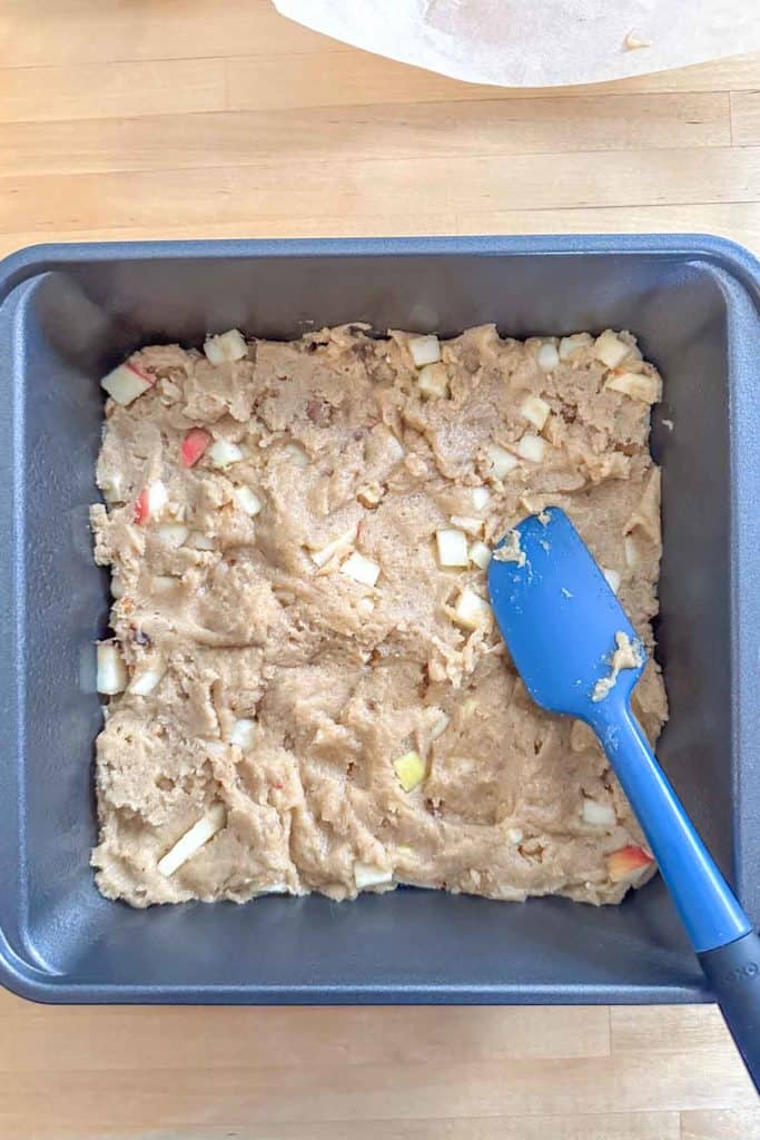A baking pan with a blue spatula in it.