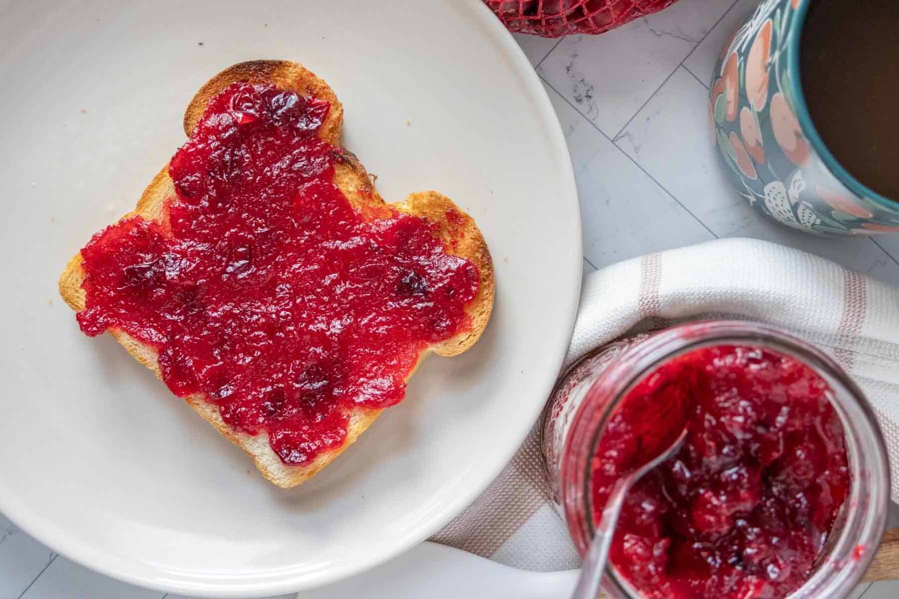 Cranberry jam on toast with a cup of coffee.