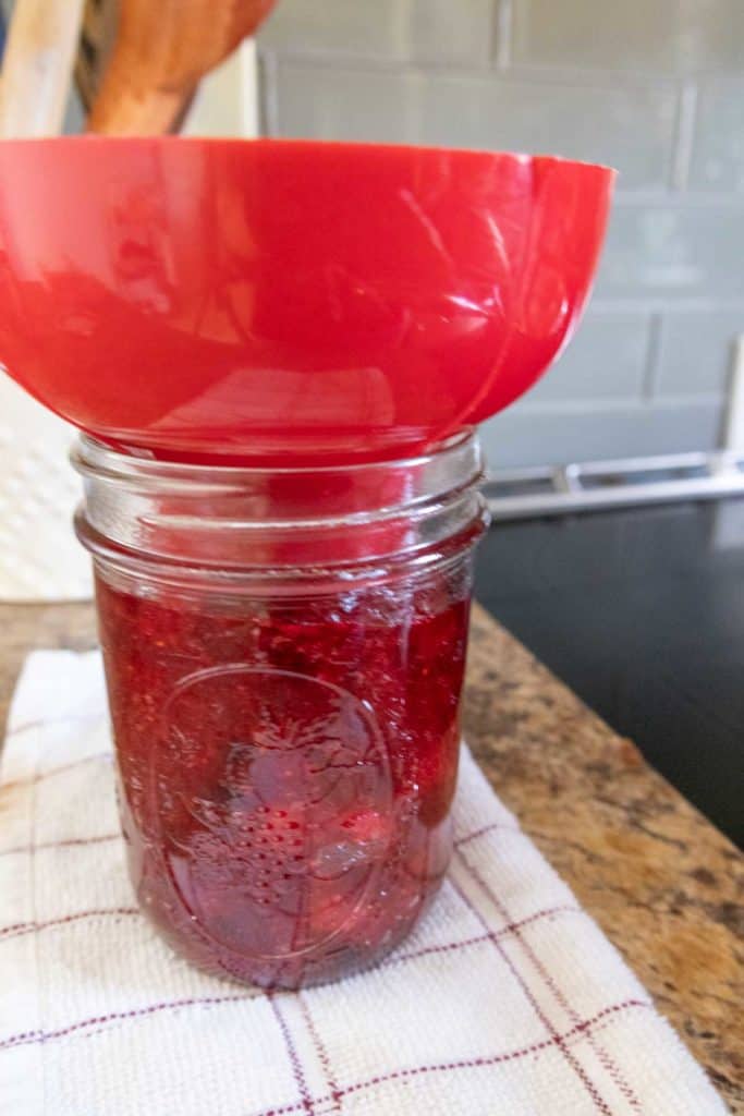 Jam in a jar with a spoon on top.