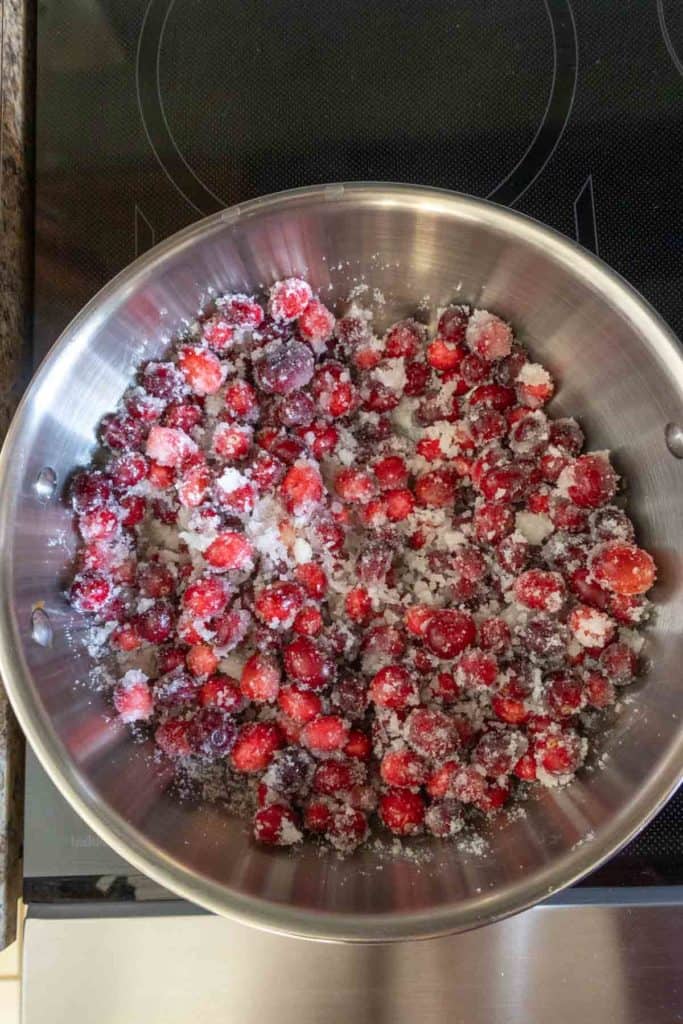 Cranberries in a bowl on top of a stove.