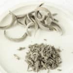 Dried sage leaves on a white plate.