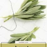 Two bundles of fresh sage tied with string rest on a white surface, with a text overlay that explains how to dry sage at home.