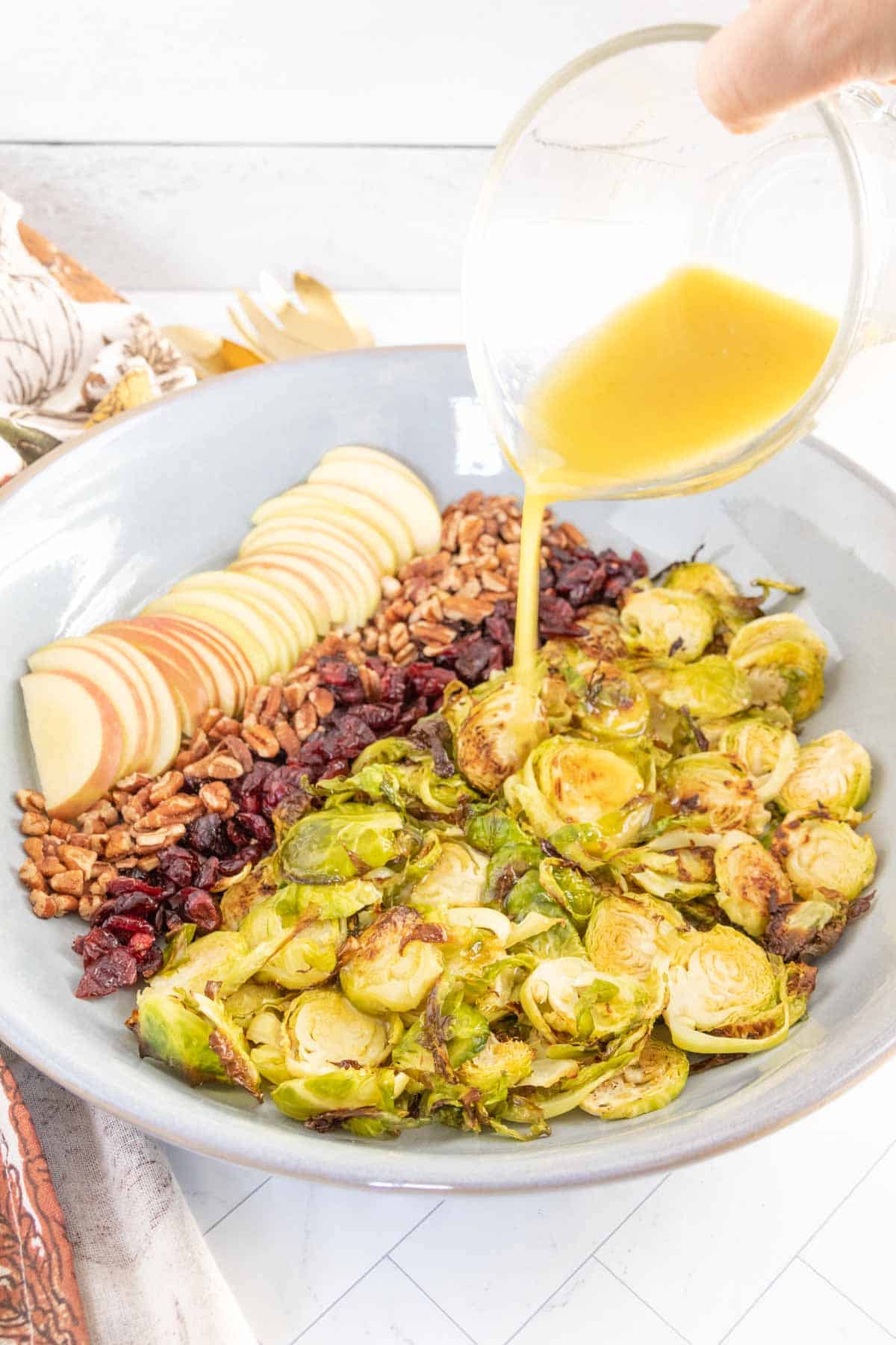 Brussels sprouts in a bowl with a drizzle of dressing.