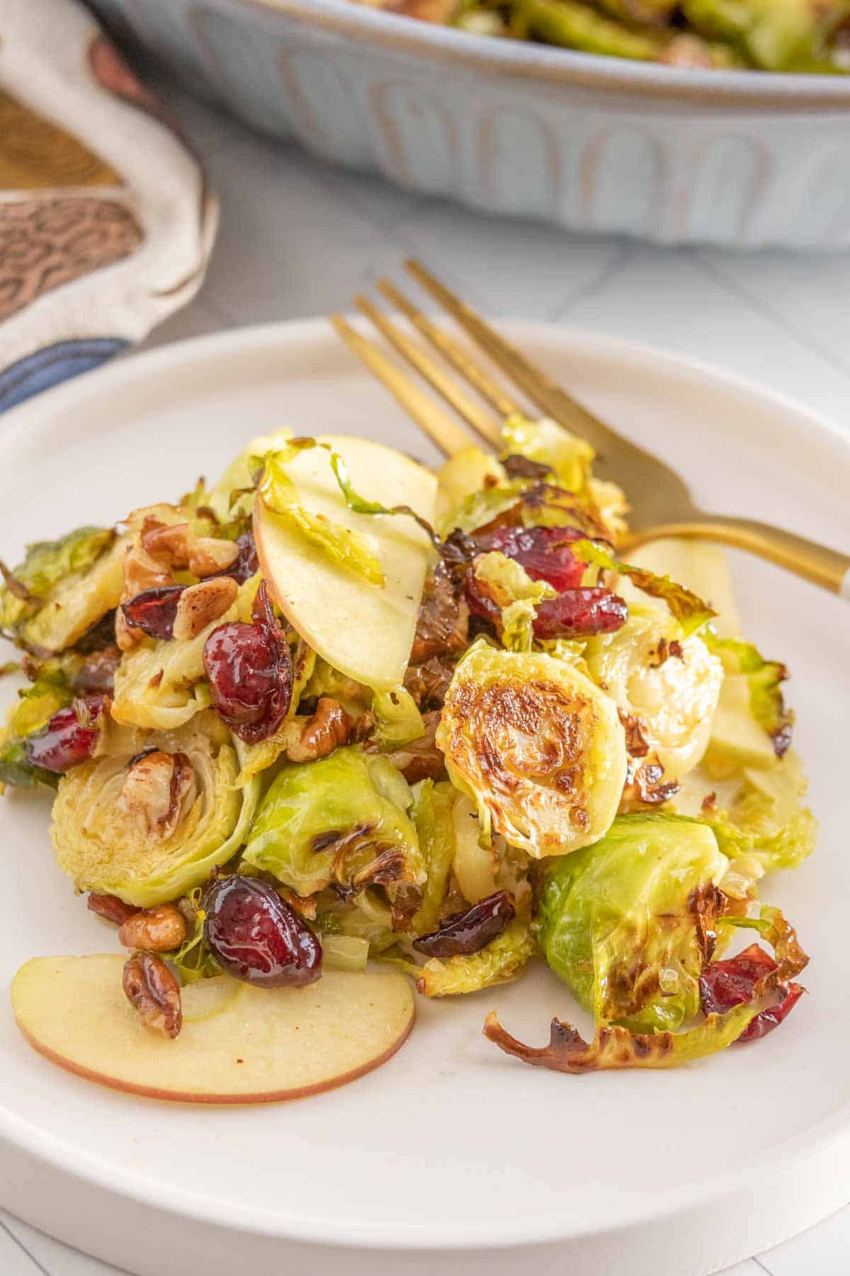 Brussels sprouts with apples and cranberries on a plate.