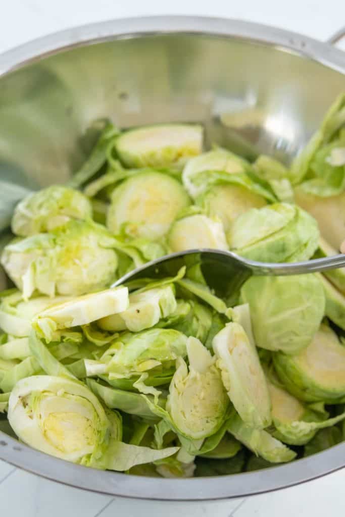 Brussels sprouts in a pan with a spoon.