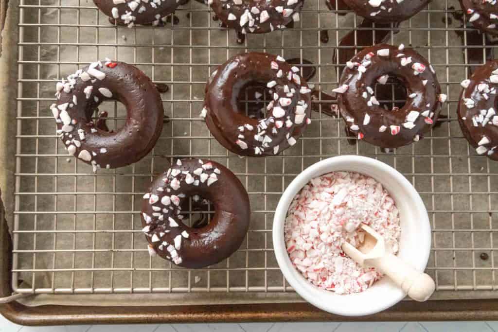 Chocolate peppermint donuts on a cooling rack.