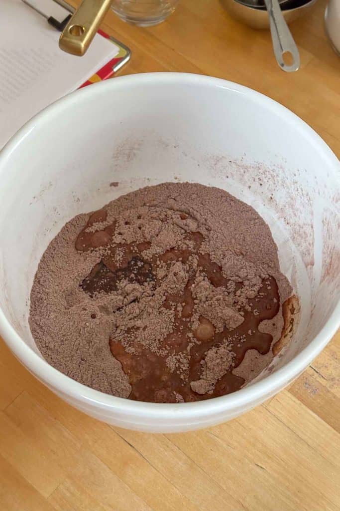 A white bowl with chocolate in it on a table.