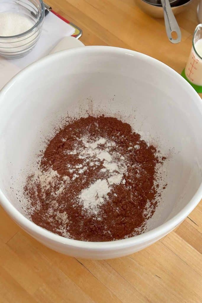 A white bowl with ingredients on a table.