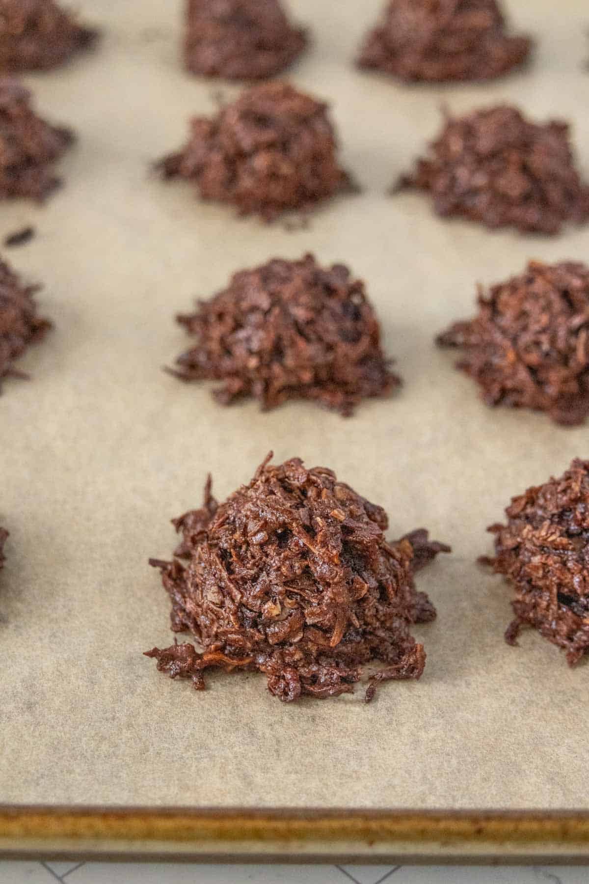 Chocolate macaroons on a baking sheet.