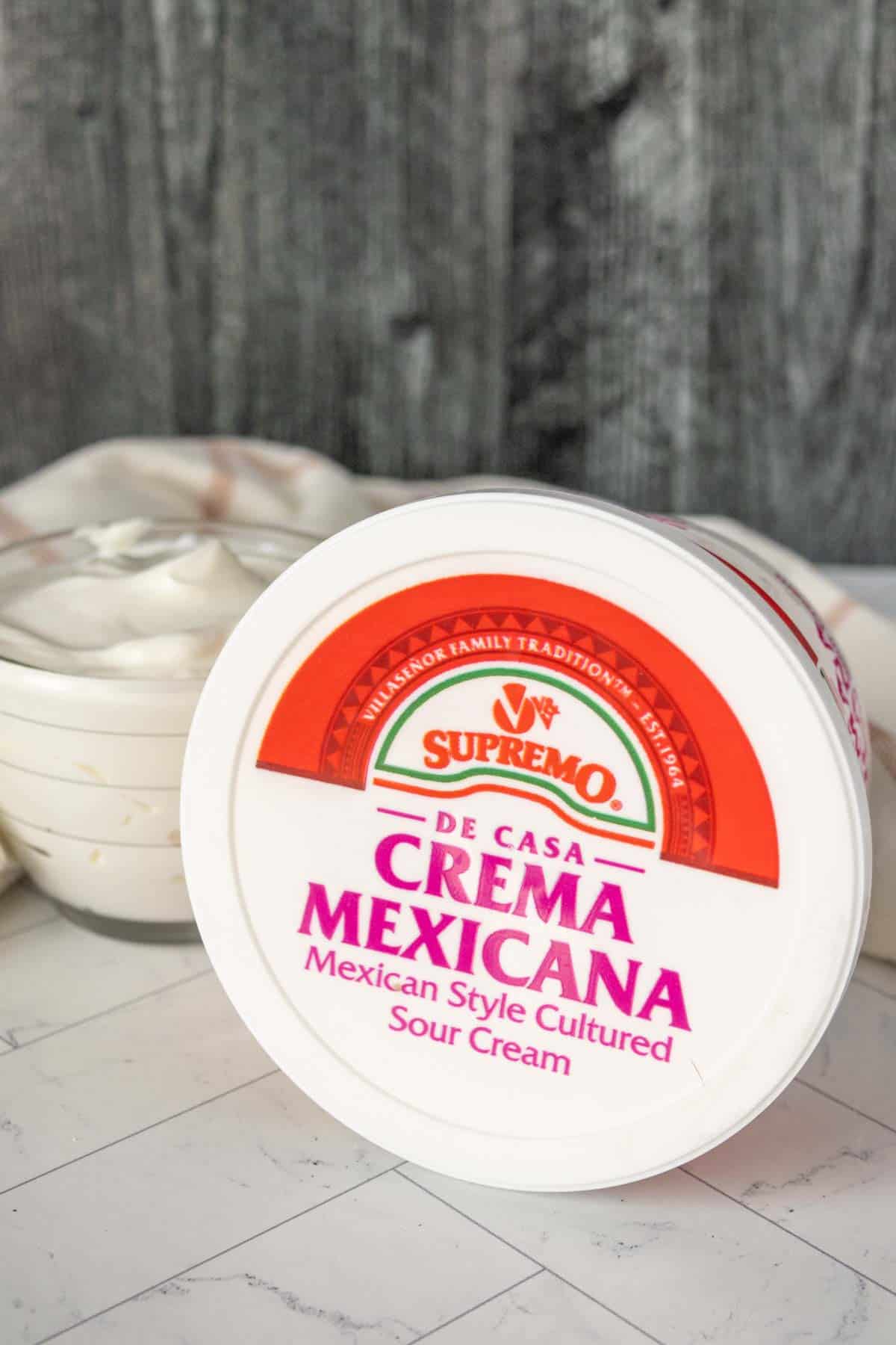 Creama mexicana on a table next to a bowl.