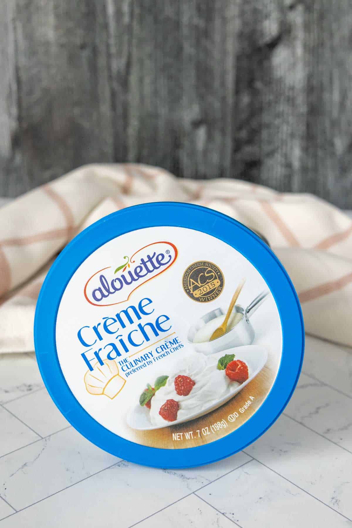 A container of creme fraiche sitting on a table.