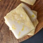 Lemon sugar cookies on a wooden cutting board.