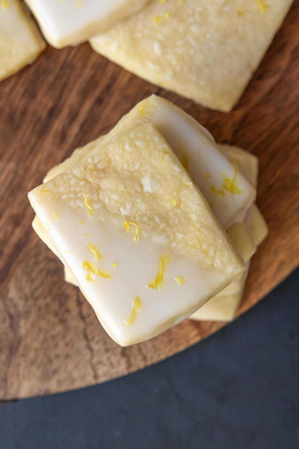 Lemon sugar cookies on a wooden cutting board.