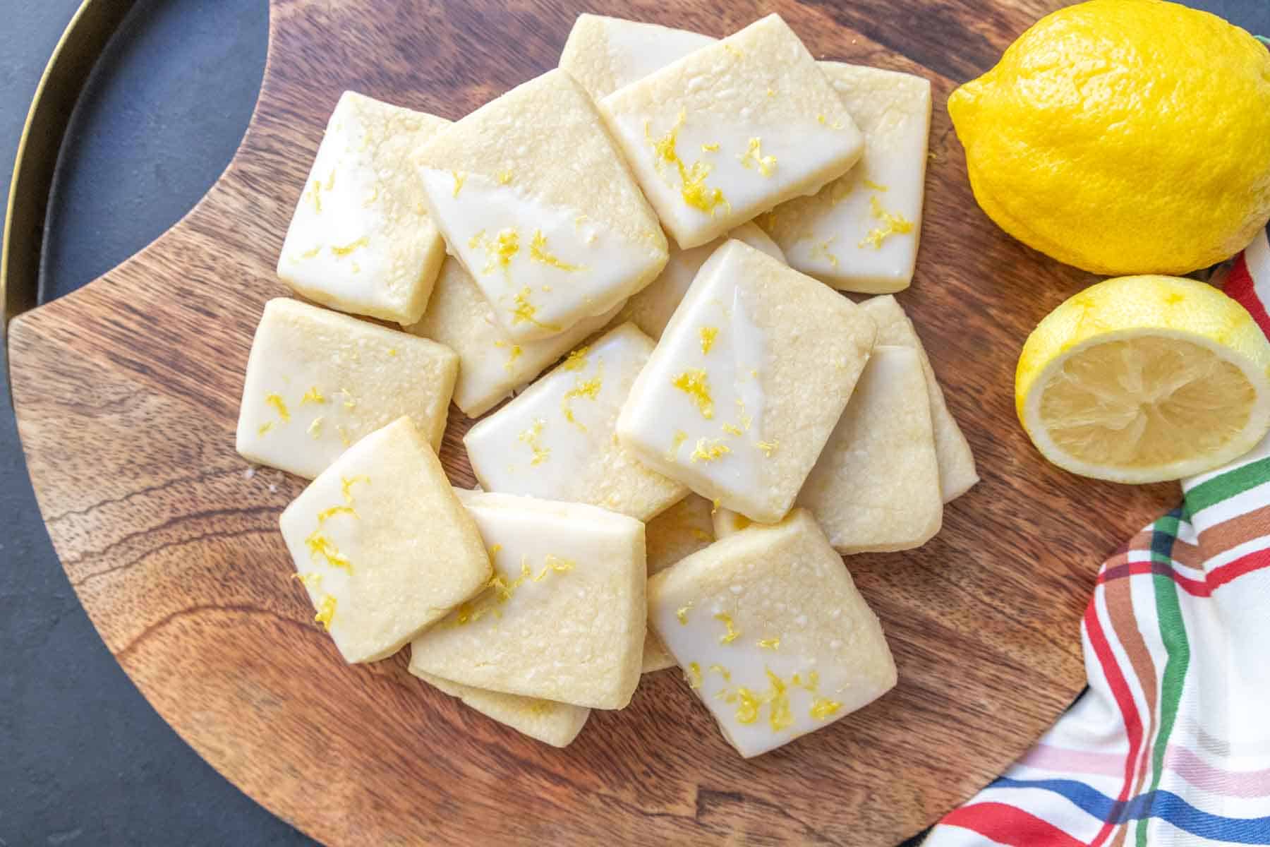 Lemon cookies on a wooden cutting board.