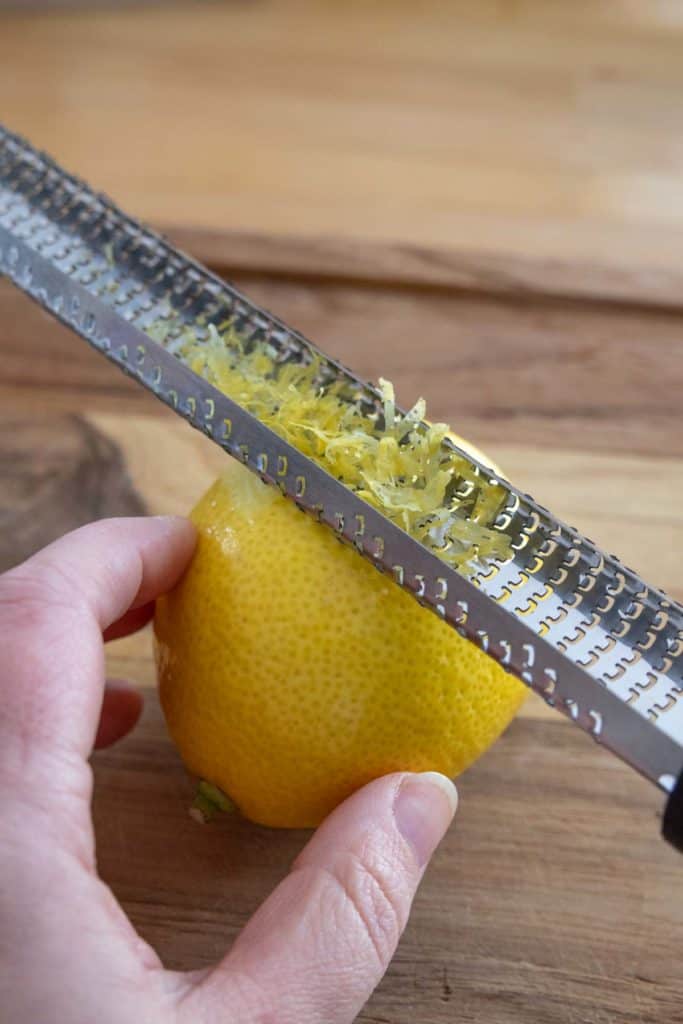 A person zesting a lemon.