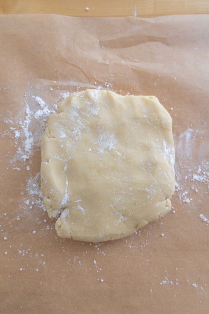A piece of dough on a piece of parchment paper.
