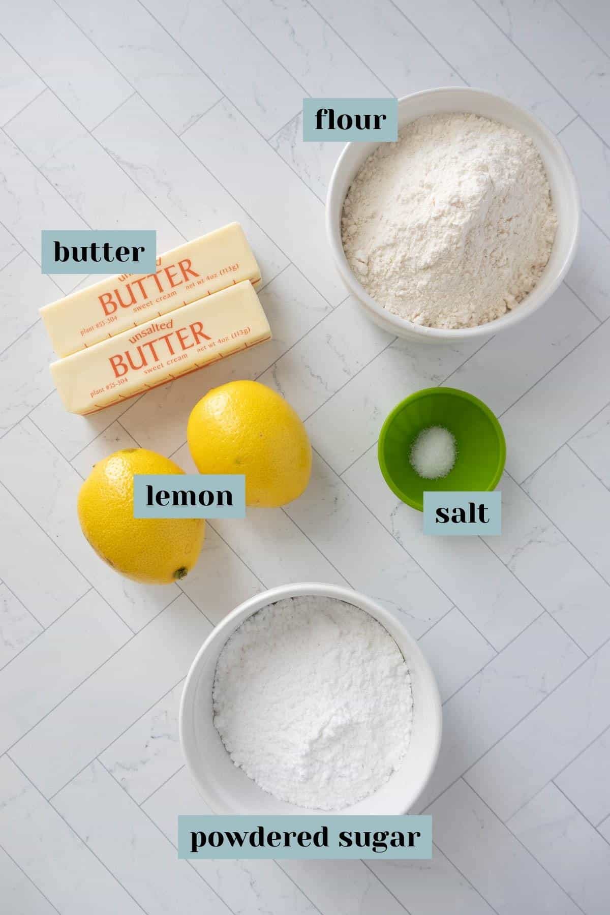 Ingredients for lemon cookies on a marble counter.