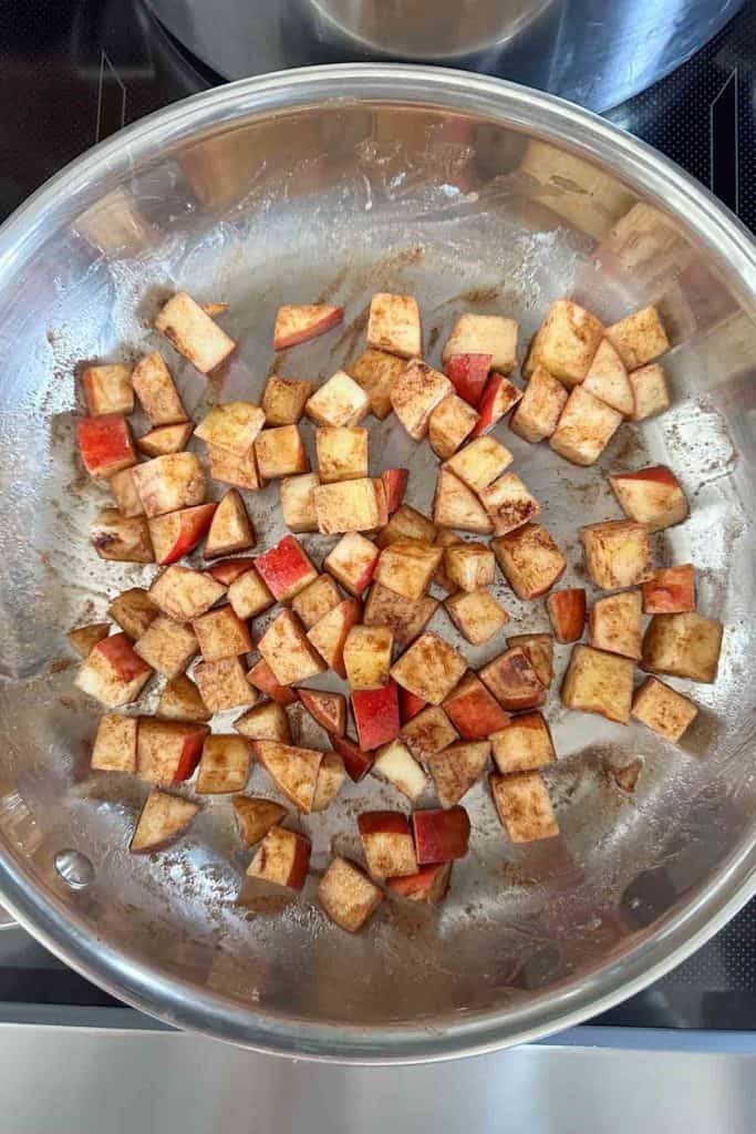 Sliced apples in a pan on top of a stove.