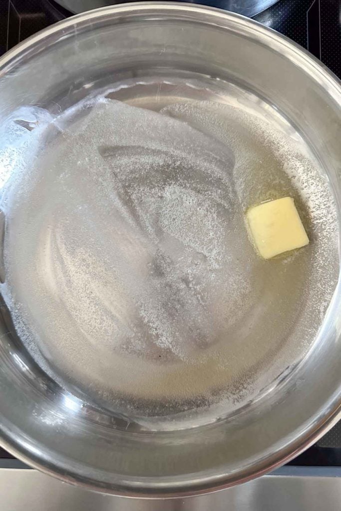 Butter in a pan on a stove top.