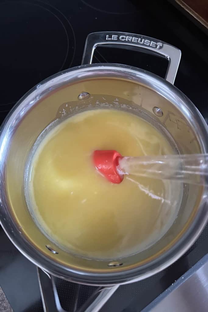 A pot filled with yellow liquid on a stove top.