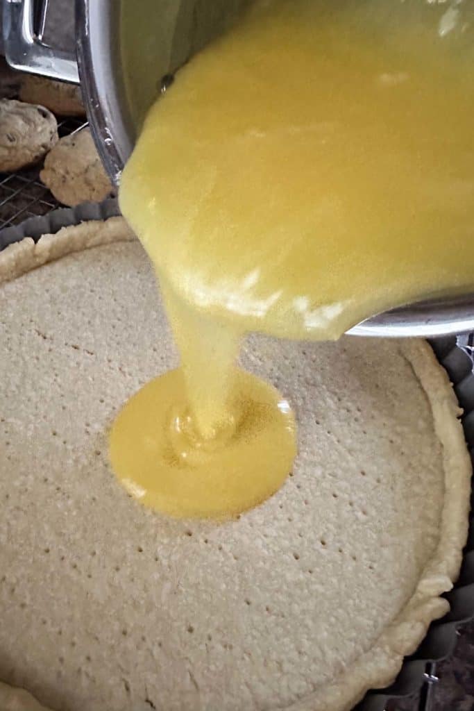 Filling being poured onto a pie crust.