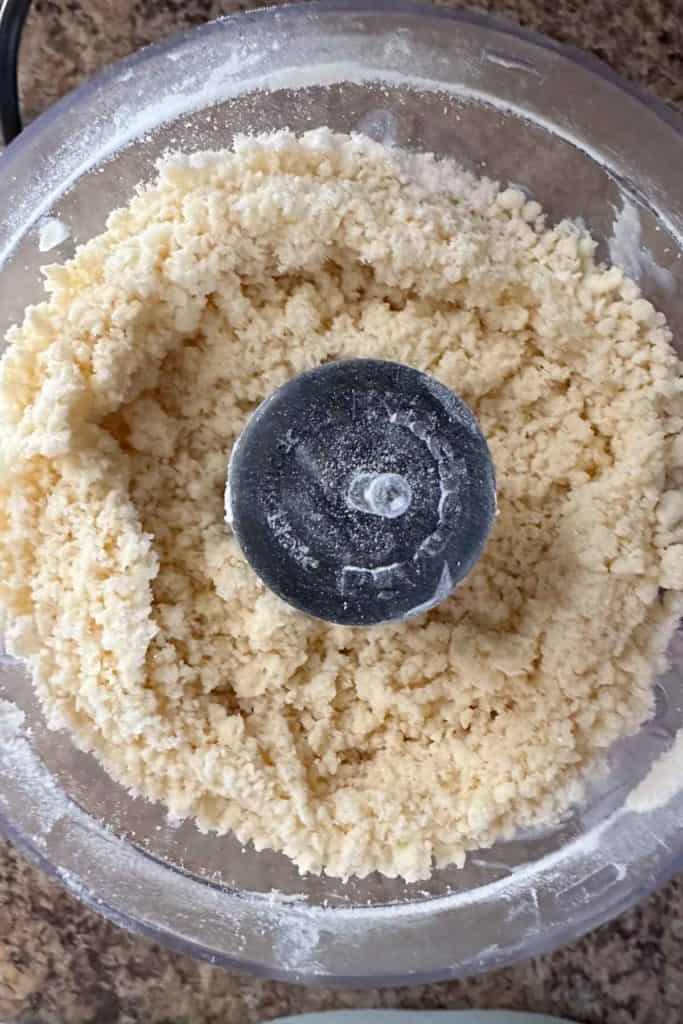 A food processor with a bowl full of flour.