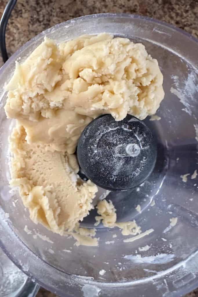 A food processor with dough in it.