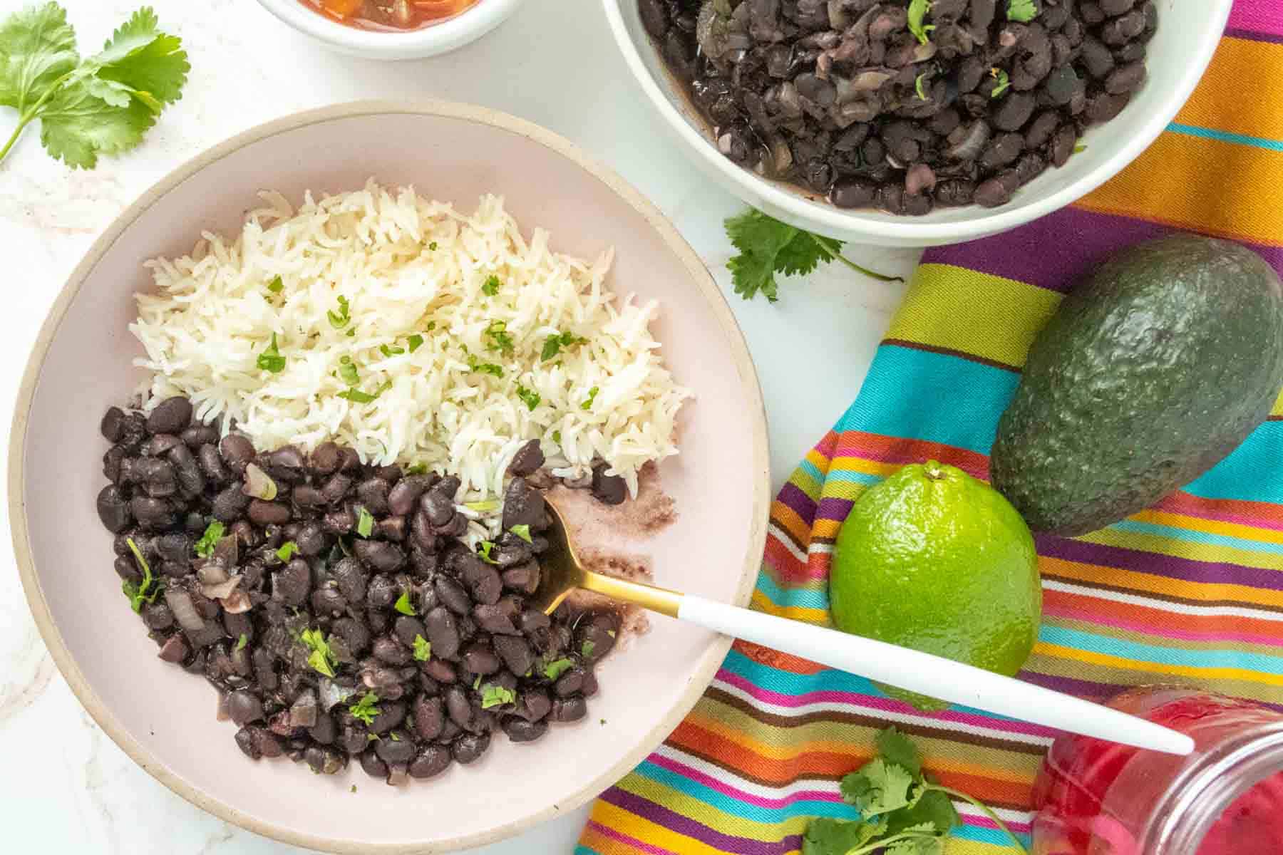 Black beans in a bowl with rice and avocado.