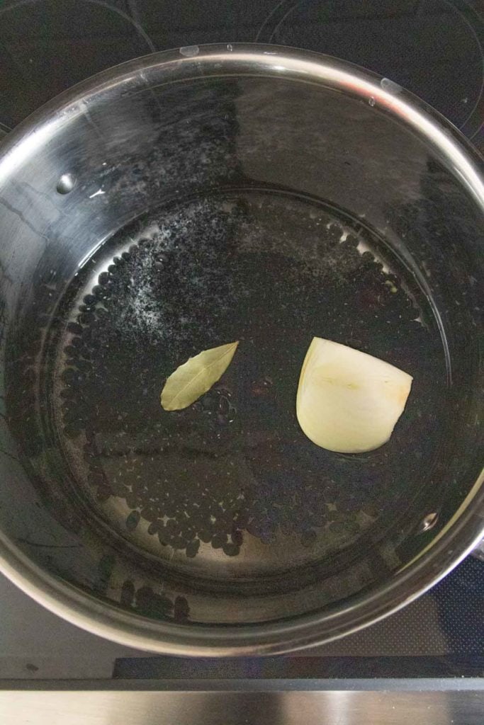 A frying pan with a piece of onion in it.