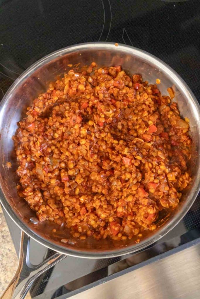 Lentils in a pan on a stove top.