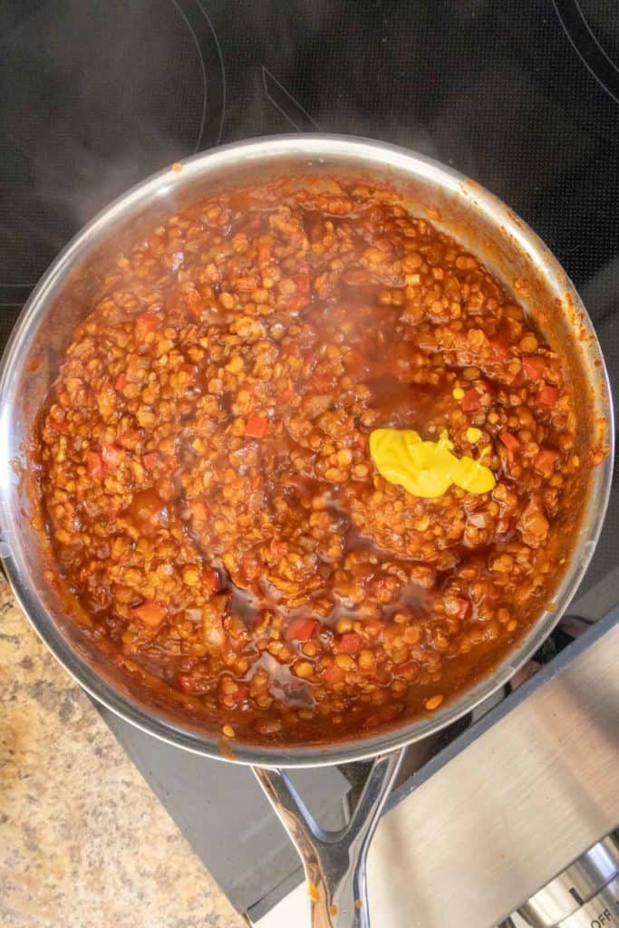 Lentils in a frying pan on top of a stove.