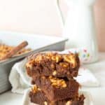 A stack of chocolate brownies on a white plate.