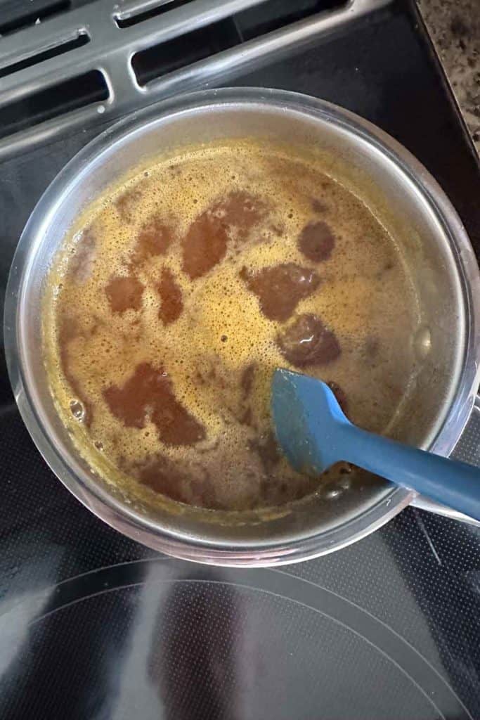 A pan with a blue spatula on top of it.