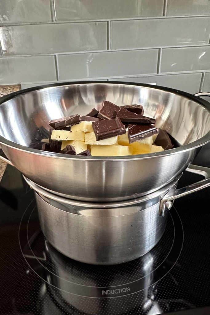 A stainless steel pan filled with chocolate chips on a stove top.