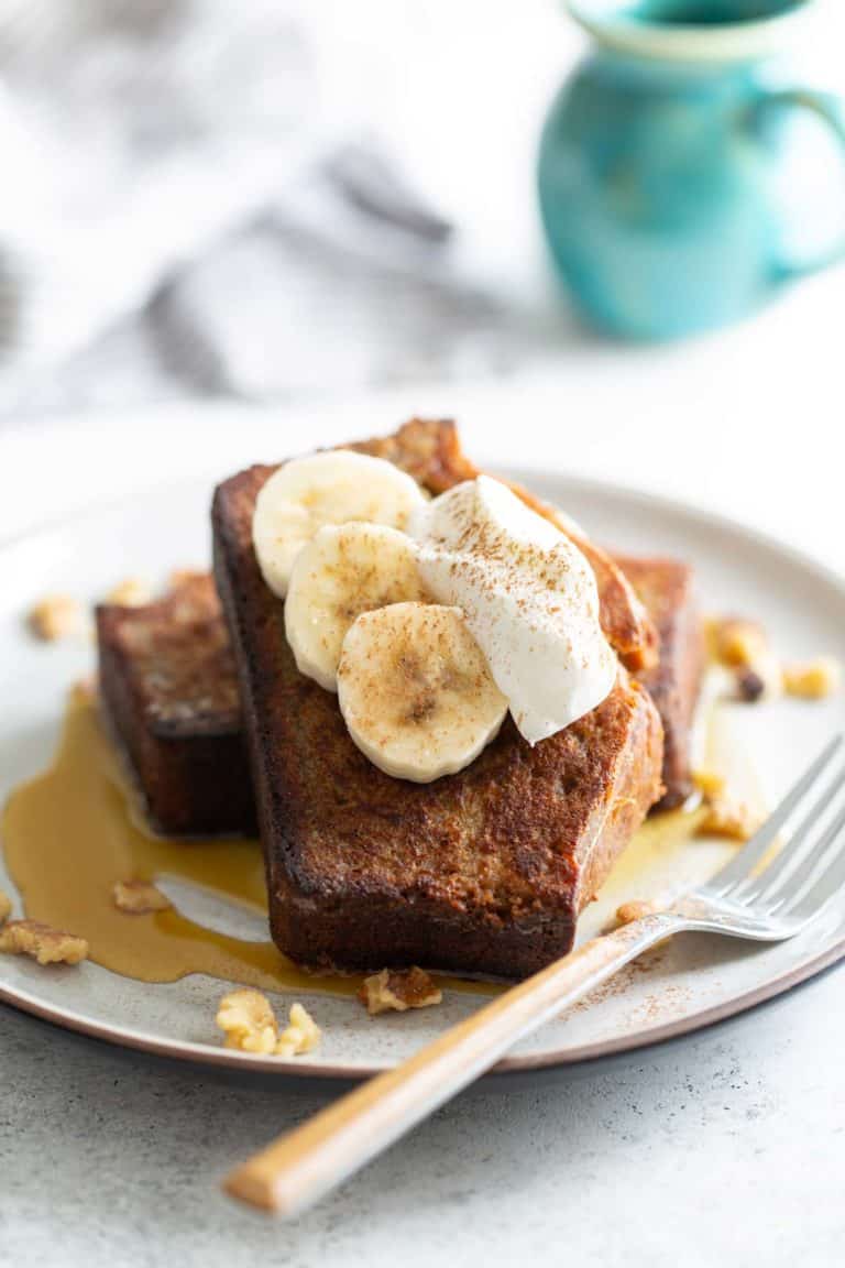 French toast topped with bananas and whipped cream.