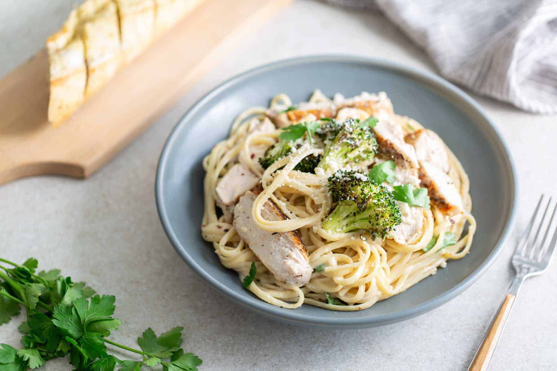 A bowl of pasta with chicken and broccoli.